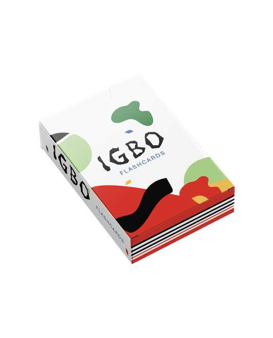 A boxed deck of IGBO Flashcards shown at an angle on a clean white background. The box features a white base with abstract organic shapes in green, red, black, and yellow, along with the text 'IGBO FLASHCARDS' printed on the top and side.